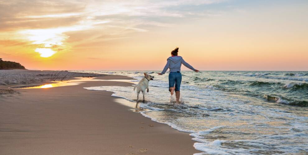 Frau mit Hund am Strand